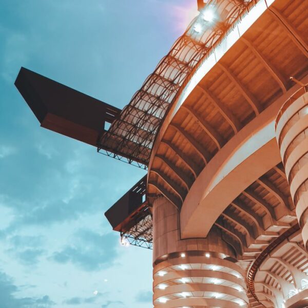 San Siro Stadium – Detail A striking low-angle view of Milan's San Siro Stadium illuminated against an evening sky.