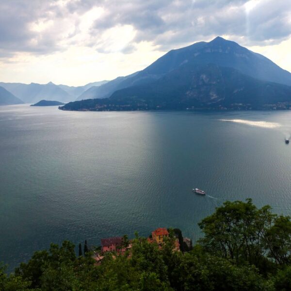 Lake Como A serene view of Lake Como in Italy with mountains and boats under cloudy skies.