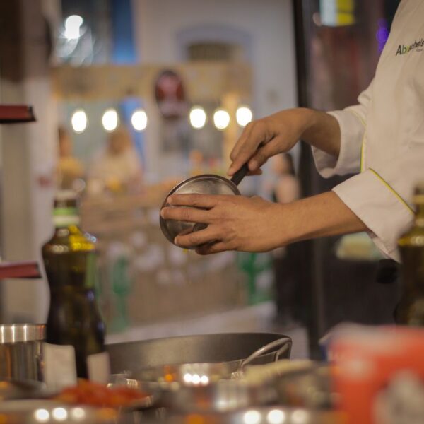 Cooking A chef carefully preparing a meal in a warmly lit, cozy restaurant kitchen setting.