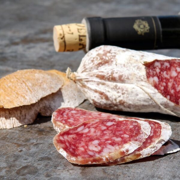 Salamella Romana Close-up of sliced salami, rustic bread, and wine for a perfect snack.