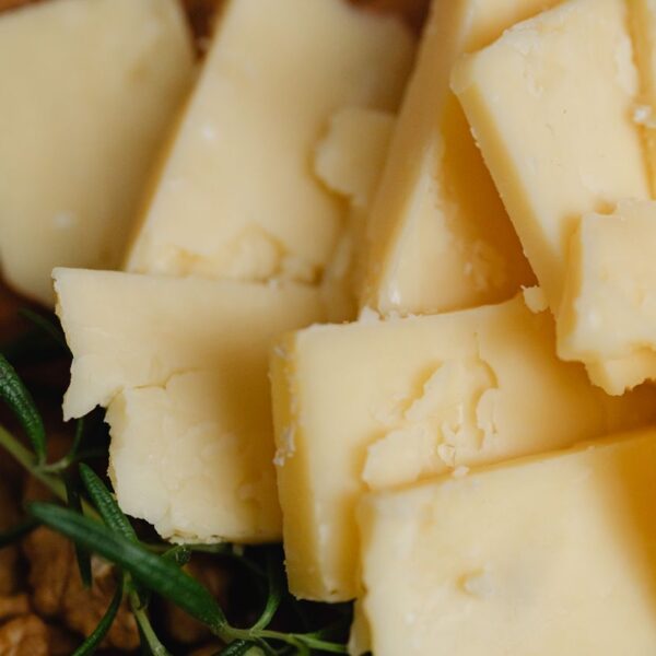 Roman Pecorino Cheese Pile of sliced cheese with rosemary and walnuts, perfect for food photography.