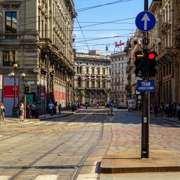 Streets in Milan View of a busy street in Milan, Italy showcasing historic architecture and tram lines.