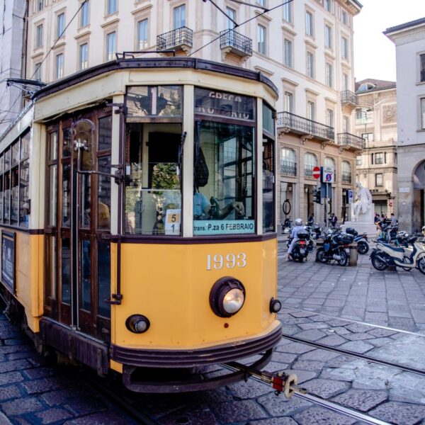 Tram in Milan Classic yellow tram in a busy European city street showcasing architecture and urban life.