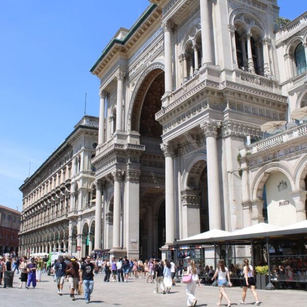 Galleria Vittorio Emanuele II Galleria Vittorio Emanuele II entrance bustling with people on a sunny day in Milan.